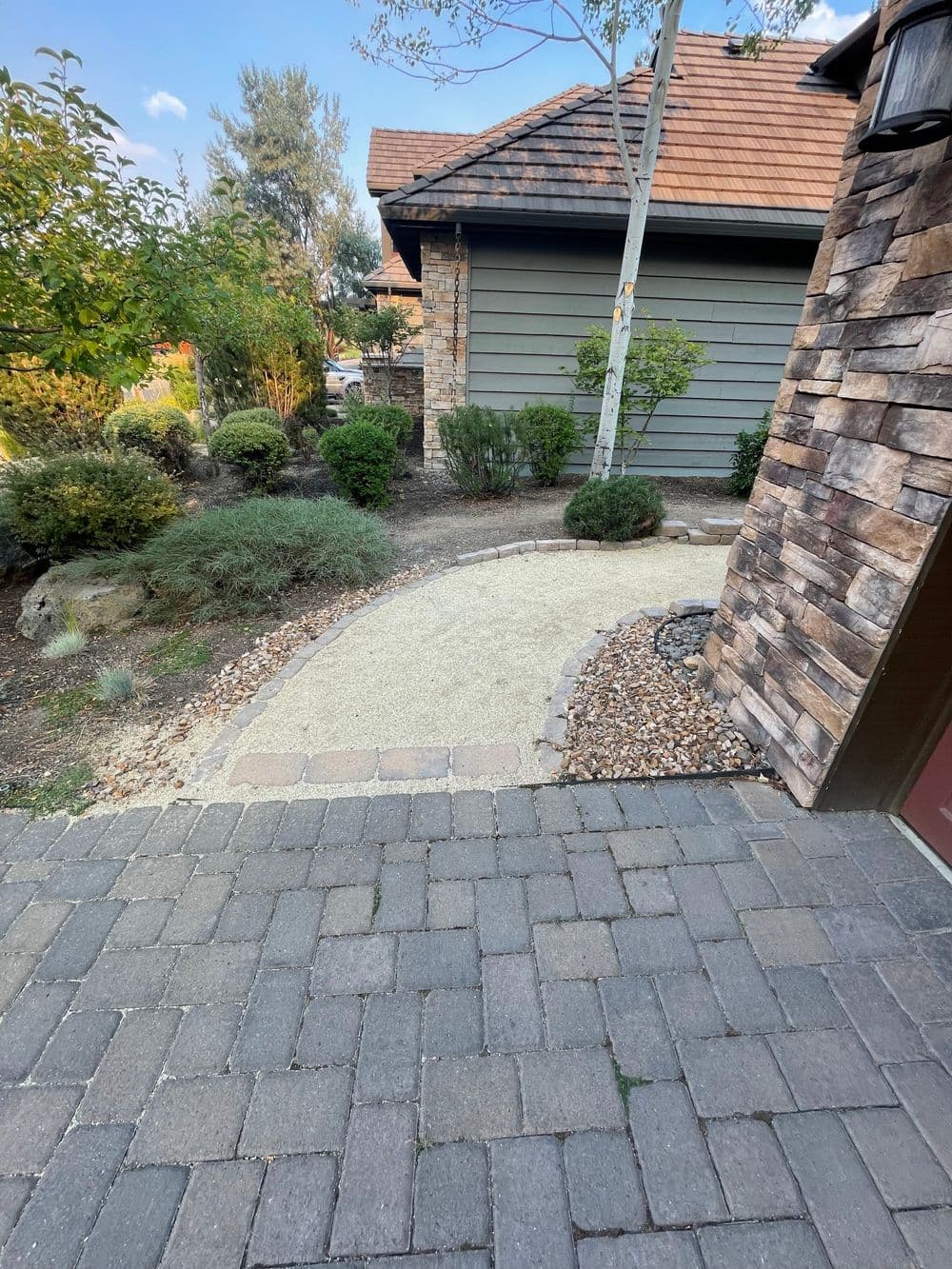 Pathway with gravel and landscaped garden leading to a house exterior.
